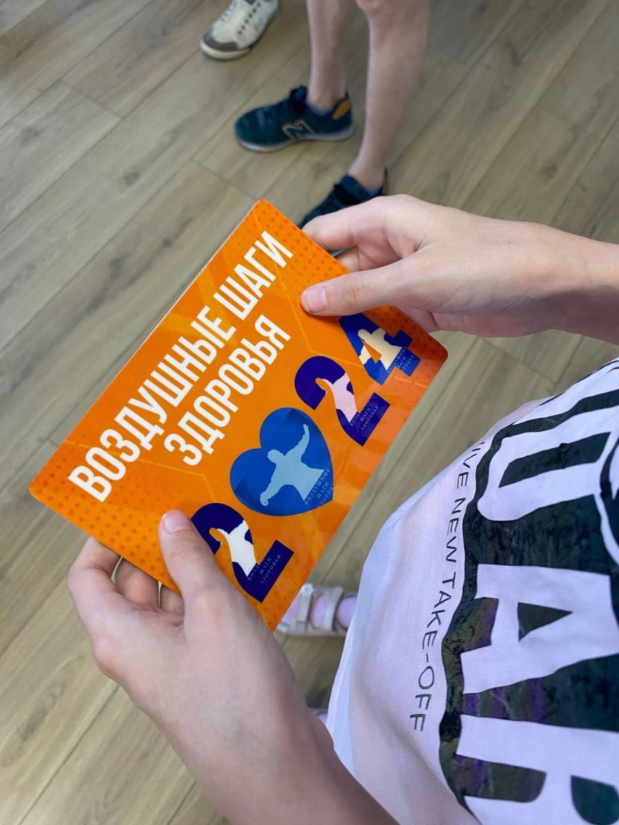 Печатная памятка проекта «Воздушные шаги здоровья» в руках участника.